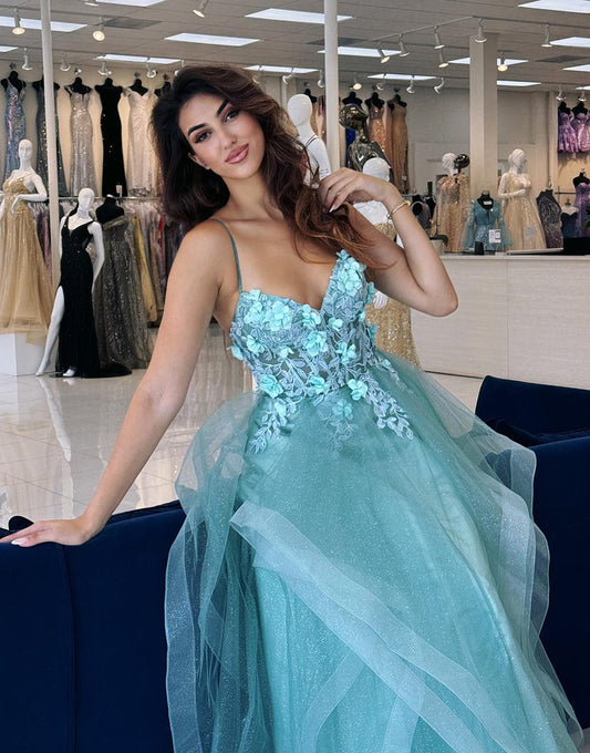 Robe de bal longue en tulle bleu à fines bretelles et à volants avec appliques