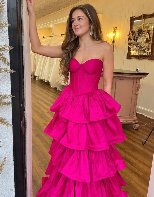 Robe de bal longue en satin fuchsia à volants et décolleté en cœur