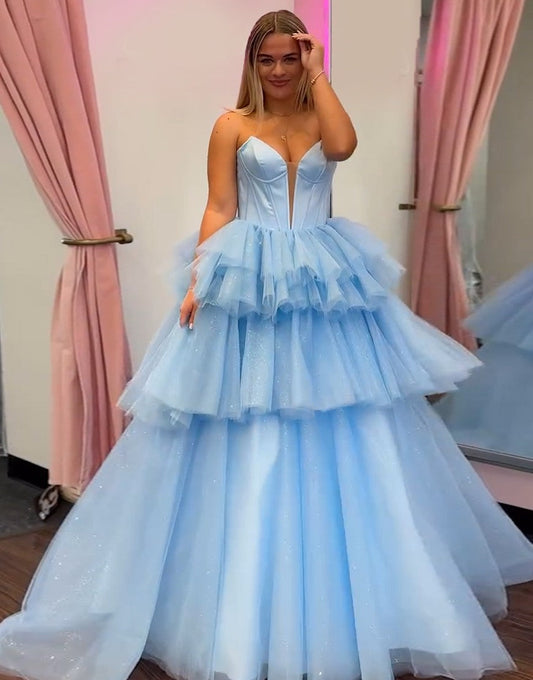 Robe de bal bleue en tulle à volants en cascade et sans bretelles