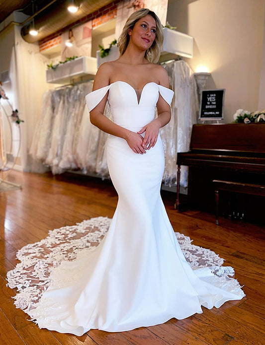 Robe de mariée longue et décolletée bordée de dentelle sirène ivoire